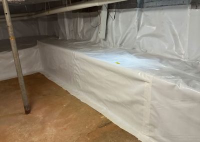 A basement with exposed pipes and ductwork, walls lined with white plastic vapor barrier, and bare concrete floor.